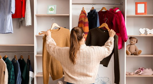 A person selecting a sweater from a neatly organized wardrobe filled with well-cared-for clothes, symbolizing mindful consumption and sustainability in fashion.